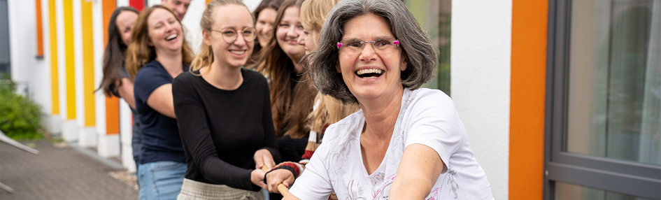 Mehrere Mitarbeiterinnen der Tagesklinik ziehen an einem Tau.